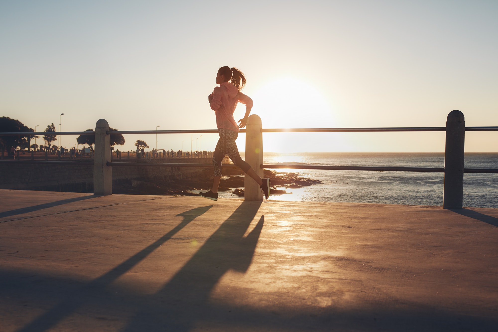 Young woman running on seaside promenade